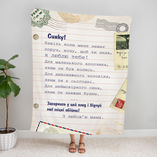 Плед у вигляді аркуша в лінійку з поштовими марками й листом «Синку!» від мами